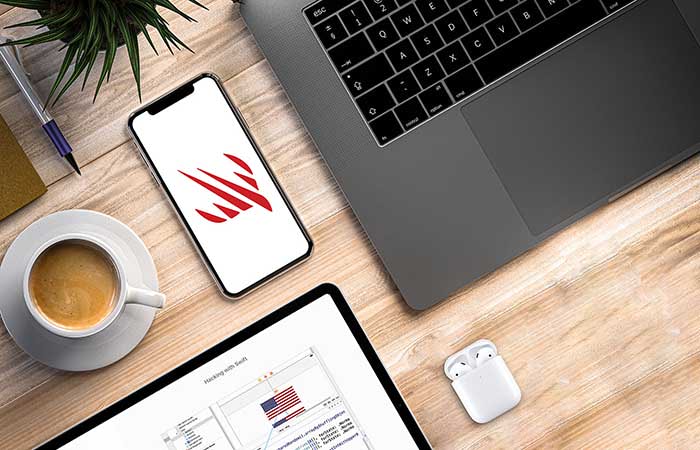 Developer coding with iPhone on desk - Hacking with Swift – learn to code iPhone and iPad apps with free ...