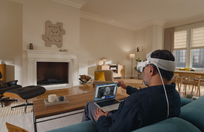 Person wearing Apple Vision Pro in living room with Apple TV - Apple Vision Pro - Apple