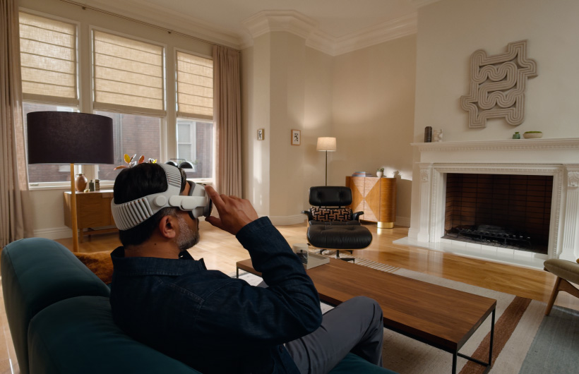 Person wearing Apple Vision Pro in living room with Apple TV - Apple Vision Pro - Apple
