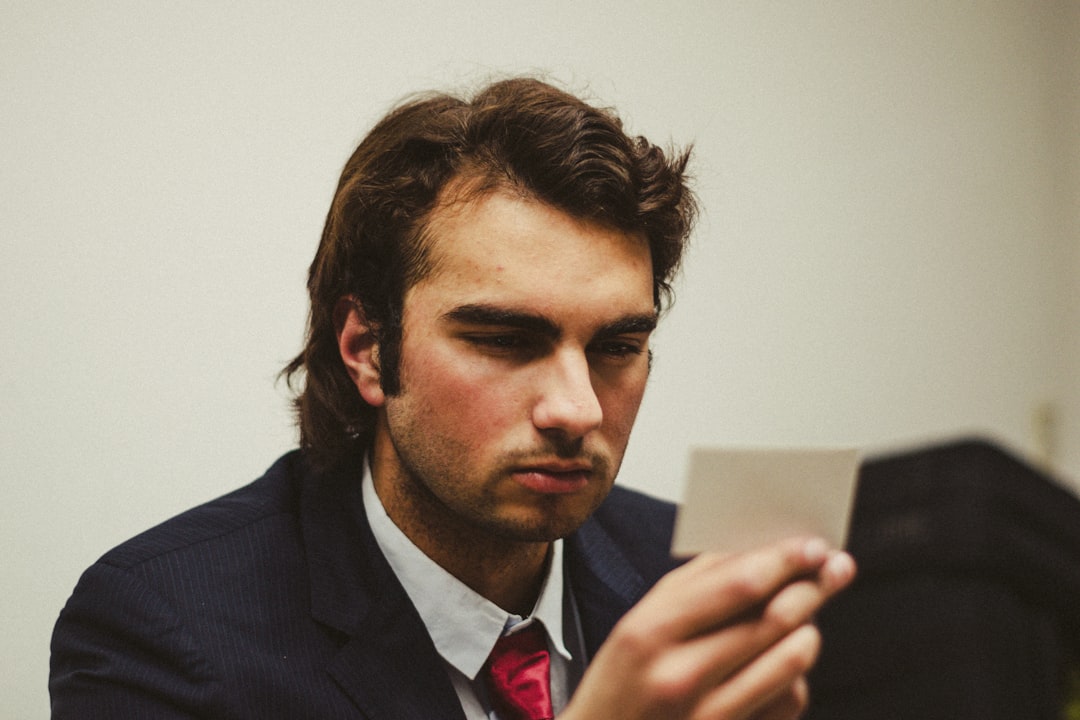frustrated person looking at smartphone - a man in a suit looking at a tablet